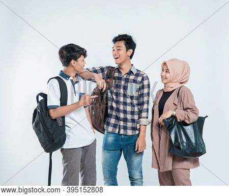 Portrait Of Conversation College Friends Carrying A Bag And Book