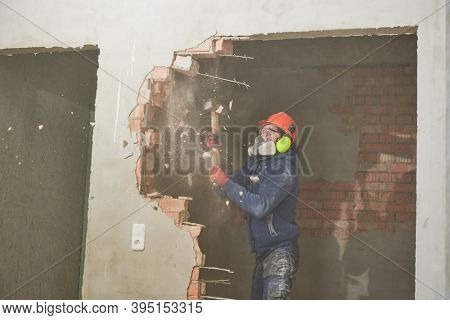 demolition work and rearrangement. worker with sledgehammer destroying wall