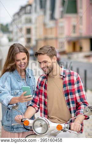 Woman Showing A Phone Scheer To Her Boyfriend