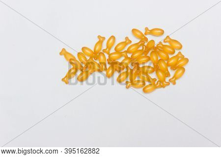 Dietary Supplements. Omega 3 Capsules In Fish Shape On Blue Background. Flat Lay. Health Support And
