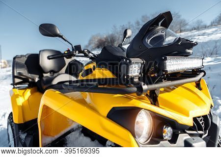 Close-up Photo Of Yellow Atv 4wd Quad Bike Stand In Heavy Snow With Deep Wheel Track.