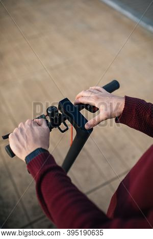 Electric Skate With Hands Touching The Buttons. Young Man With An Electric Skate To Move Around The 