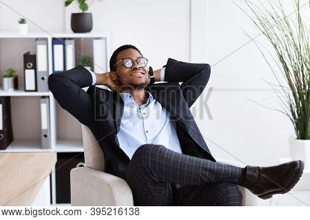 Work Break. Young African American Businessman In Formalwear Relaxing At Workplace, Leaning Back On 