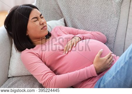 Pregnant Chinese Lady Suffering From Pain Touching Belly Having Painful Contractions Spasms Lying On