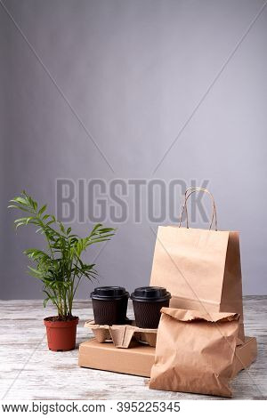 Paper Cups And Eko Packages On Wooden Floor. Order Of Food Delivery. Flowerpot On The Wooden Board.