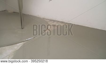 The Self-leveling Floor Is Poured Onto The Floor. The Worker Pours The Solution From The Self-leveli