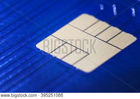 Closeup Defocused View Of Blue Plastic Credit Card Emv Micro Chip. Selective Focus. Financial And Ba