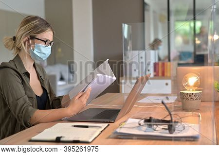 Office worker wearing surgical face mask in open space area