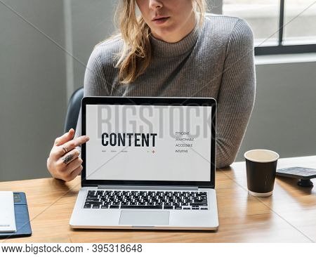 Blond woman pointing at a laptop screen