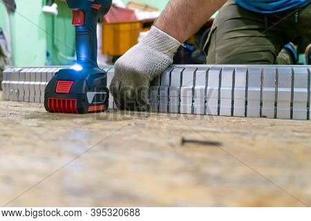 Male Employee Twists An Aluminum Profile With Slits. Production Of An Aluminum Profile According To 