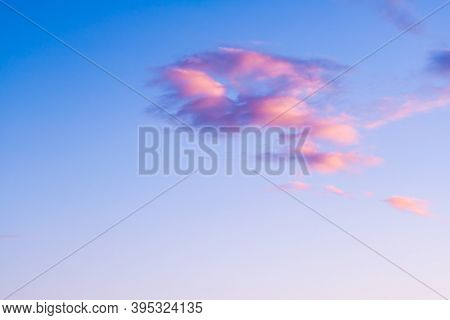 Contrasting Iridescent Clouds Of Pink, Blue And Orange In The Clear Blue Sky At Sunset. Bright Satur
