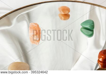 Colorful gemstones on white fabric texured background