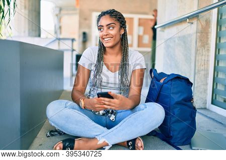 Young african american student woman smiling happy using smartphone at the university campus