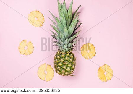 Ripe Juicy Pineapple On Pink Background And Dried Pineapple Wedges Around. Fruit Chips. Healthy Eati