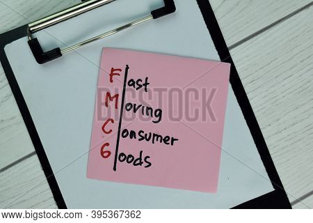 Fmcg - Fast Moving Consumer Goods Write On Sticky Note Isolated On Wooden Table.