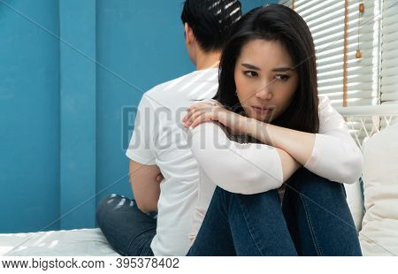 Unhappy Couples Sitting Behind Each Other On The Bed And Avoid Talking Or Looking At Each Other, Cau
