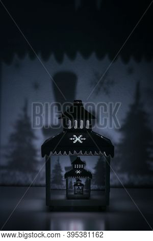 Drosde Effect Image Of Christmas Candle Lantern With Snowflake Casting Shadows Of Christmas Trees