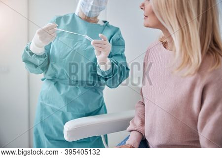 Woman Looking At Her Pharyngeal Smear Collected By The Nurse