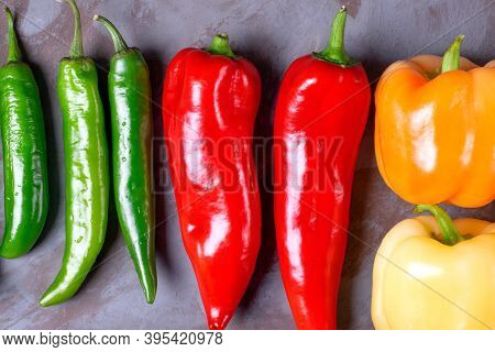Assortment Of Peppers On The Grey Table. Top View. Multicolored Harvest Of Homegrown Vegetable