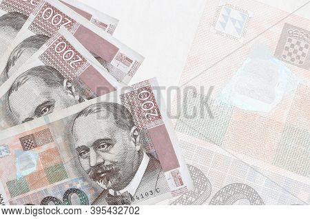 200 Croatian Kuna Bills Lies In Stack On Background Of Big Semi-transparent Banknote. Abstract Busin