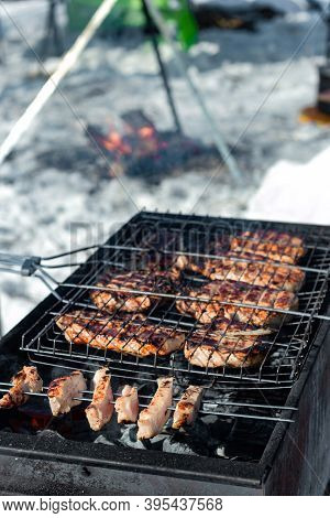 Winter Barbecue Outdoors, Grill Steak And Fork With Meat Over Hot Coals In Bbq At Campside Cookout, 