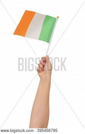 A Hand Holdiing The Flag Of Ireland Against A White Background