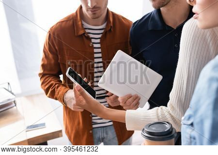 Cropped Of African American Woman Holding Smartphone With Blank Screen Near Colleagues On Blurred Fo