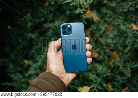Paris, France - Nov 11, 2020: Male Hand Holding Against Juniper Tree Background New Apple Computers 