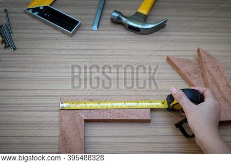 Close Up View Of A Woman's Hands Measuring Wooden Plank With A Tape Measure With A Set Collection Of