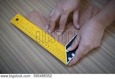 Female Hands Using A Try Square To Check That The Woodworking Corners Are Square On Wooden Board