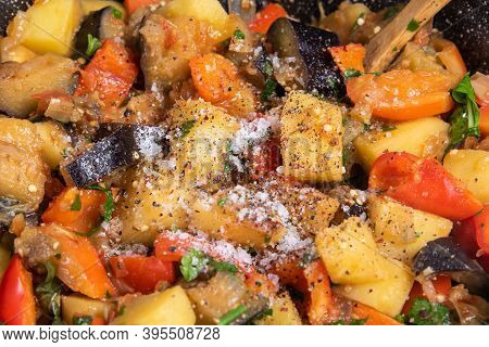 Cooking A Traditional Italian Vegetable Stew With Potatoes, Eggplants And Peppers In A Frying Pan - 