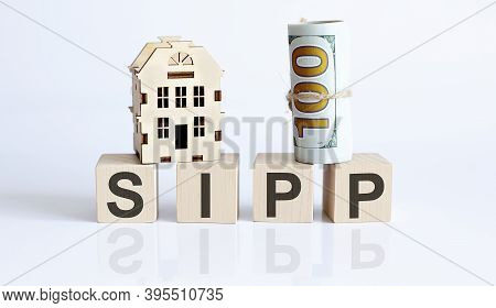 Letters Sipp On The Wooden Cubes On Table With Wooden House And Dollar