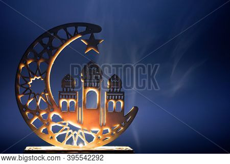 Ornamental Arabic decoraion with burning candle glowing at night and glittering golden bokeh lights. Festive greeting card for Muslim holy month Ramadan Kareem.