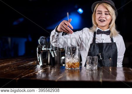 Young Girl Bartending Demonstrates The Process Of Making A Cocktail