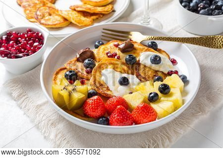 Homemade low calarie curd cheese pancakes with fruit salad and maple sirup