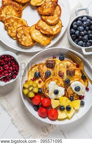 Homemade low calarie curd cheese pancakes with fruit salad and maple sirup