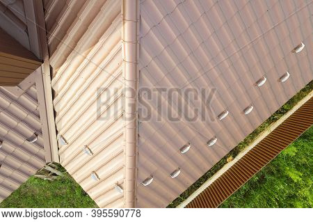 House Roof Structure Covered With Brown Metal Tile Sheets.