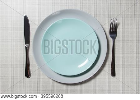 Empty Plate With Table Items. Empty Plate.on The Table Is A White Empty Plate, A Knife And Fork On A
