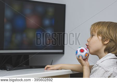 The Child With Enthusiasm Looks At The Monitor Screen. An Educational Program Or Useful Cartoons For