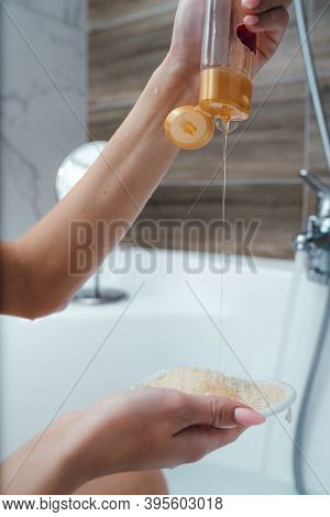 Close-up Of Female Hands With Shower Gel. Girl Pours Shower Gel Into The Palm While Sitting In A Bub
