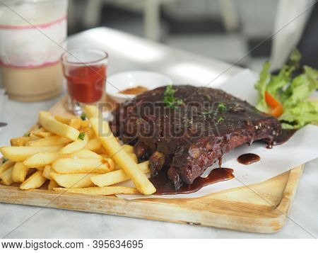 Pork Spareribs Bbq, Barbeque Pork Ribs With French Fries Vegetable Salad, Tomato Sauce In A Clear Gl