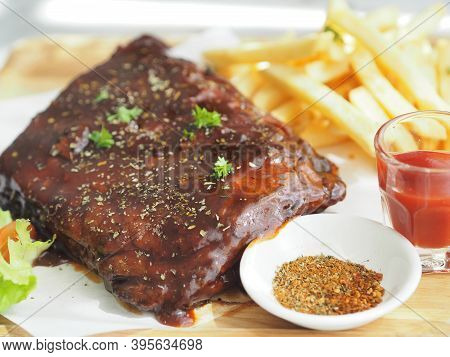 Pork Spareribs Bbq, Barbeque Pork Ribs With French Fries Vegetable Salad, Tomato Sauce In A Clear Gl