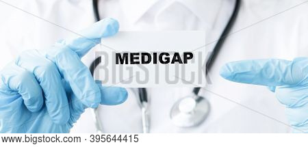 Doctor Holding A Card With Text Medigap, Medical Concept