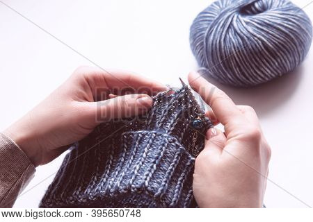 Female Hands With Knitting Needles To Knit Wool Violet Sweater On White Background. Woman Knitting W