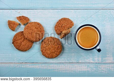 Close Up Several Round Artisan Oatmeal Cookies And Pannikin Mug Of Coffee On Blue Painted Rustic Woo