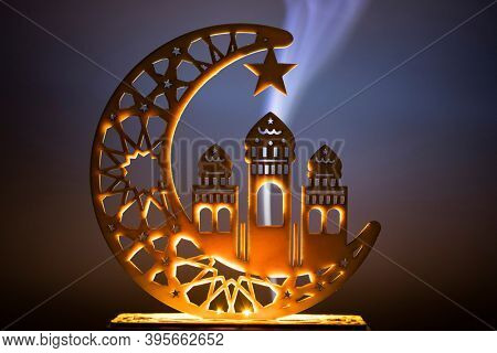 Ornamental Arabic decoraion with burning candle glowing at night and glittering golden bokeh lights. Festive greeting card for Muslim holy month Ramadan Kareem.