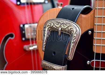 Electric Guitars And Leather Strap With Silver Buckle Close-up.