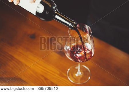 Closeup Shot Of Glass With Wine Pouring By Sommelier