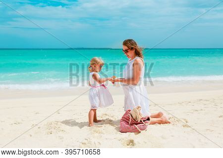 Mother And Daugghter Applying Sunblock Cream On Beach