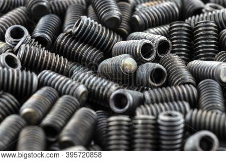 Background Made From A Macro Shot Of Scattered, Black Grub Screw On Table.